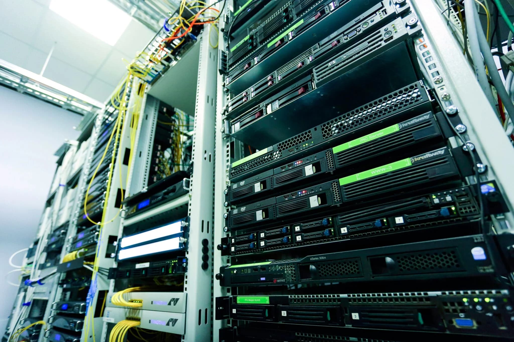 Rows of server racks and networking equipment in a data center, representing financial market infrastructure