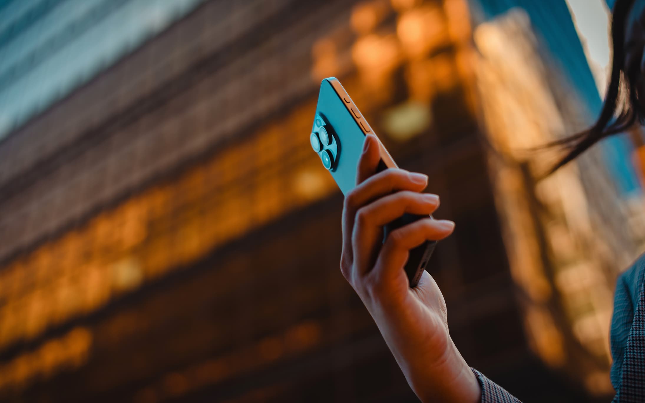 A person holding a smartphone, representing the squeeze on device affordability across Africa