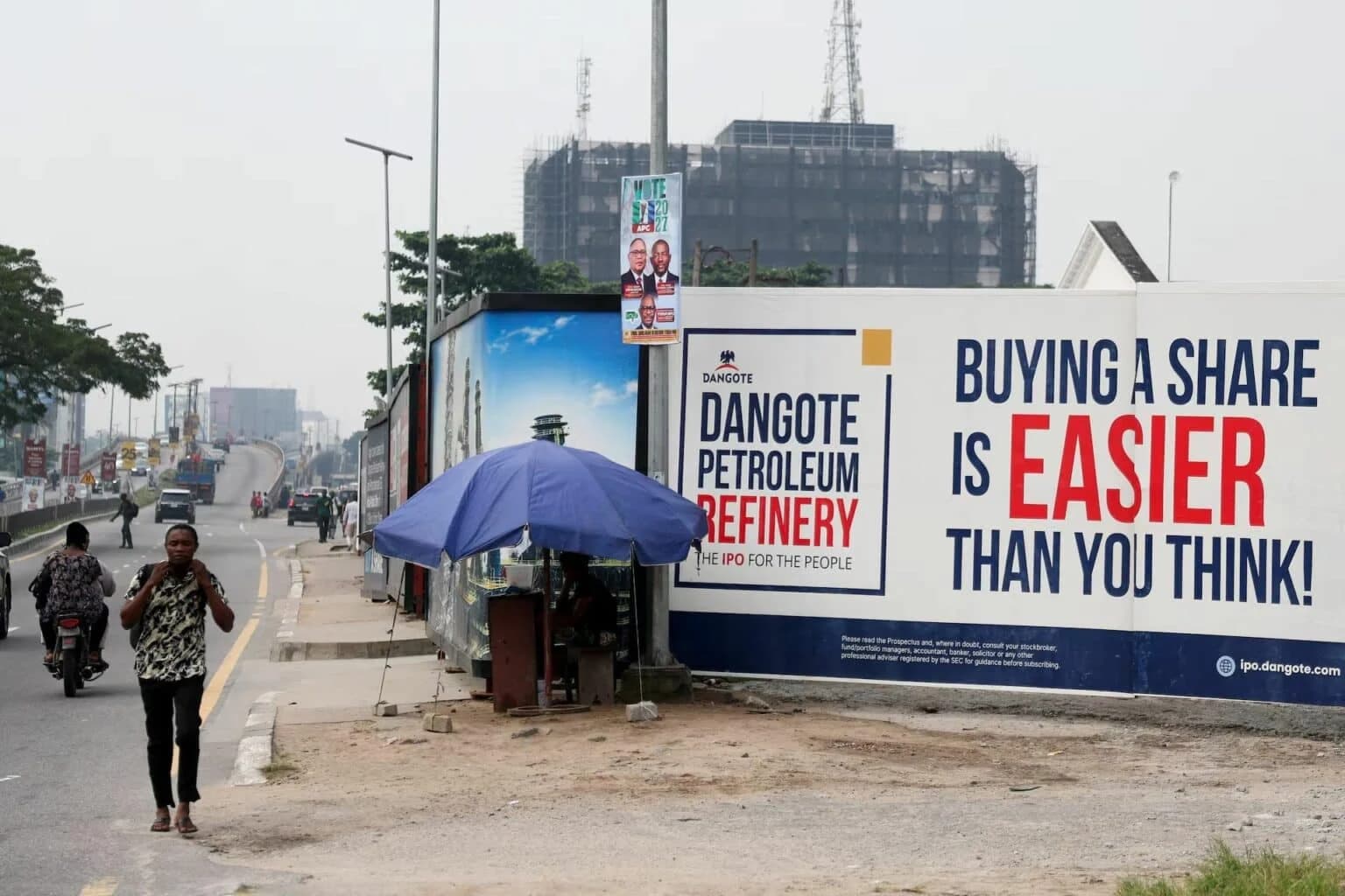A roadside billboard in Lagos advertising the Dangote Petroleum Refinery IPO, reading 'Buying a share is easier than you think'