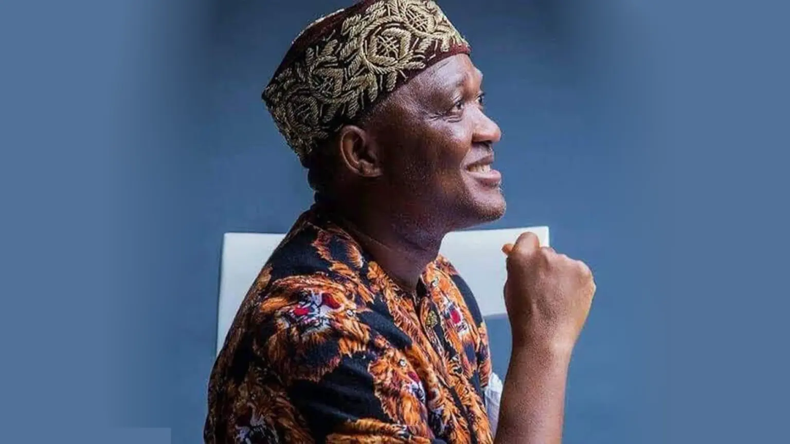 Dennis Agbo, federal lawmaker for Igbo-Eze North/Udenu, smiling while seated in traditional attire