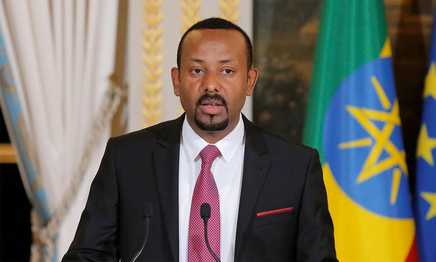 Ethiopian Prime Minister Abiy Ahmed speaking at a podium beside the Ethiopian flag