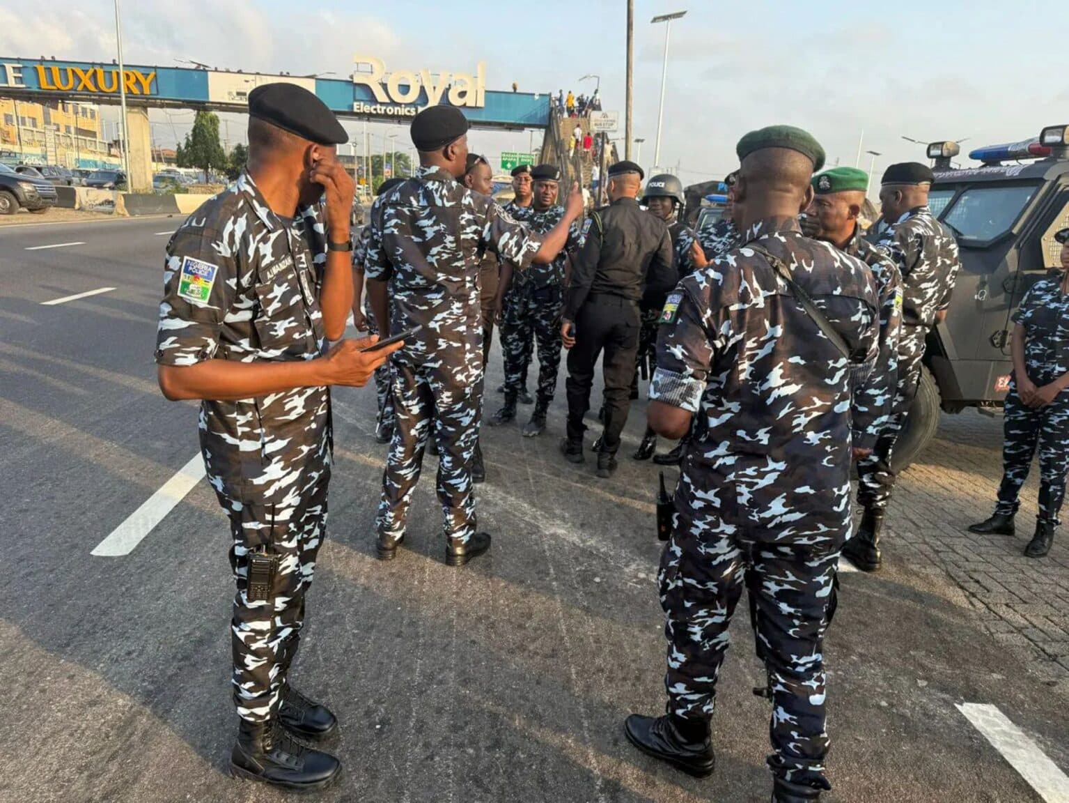 Nigerian police officers gathered on a highway during a security deployment