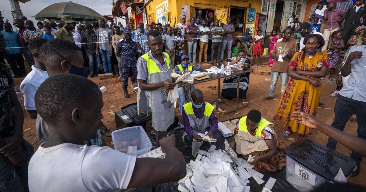 Election workers counting ballots in the open while a crowd looks on in Uganda